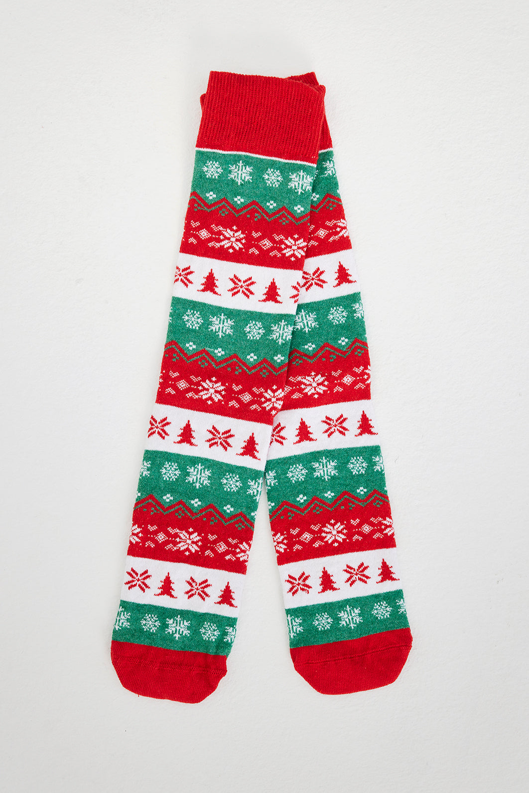Ein Paar Füße mit rot, grün und weiß gemusterten Weihnachtssocken.